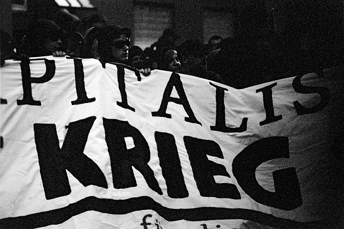 Members of the black bloc hold a banner. Image: Michel Meijer