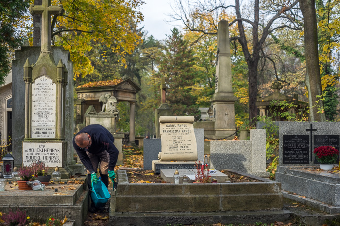 All Saints' Day at Rakowicki Cemetery in Kraków, Poland 2019. A man cleans a grave, All Saints' Day in Poland. Image: Michel Meijer