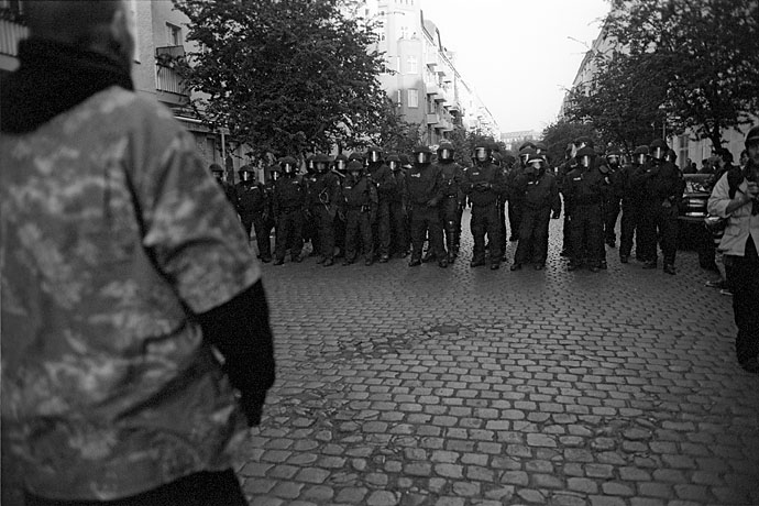 A protester stands facing a squad of police officers. Image: Michel Meijer