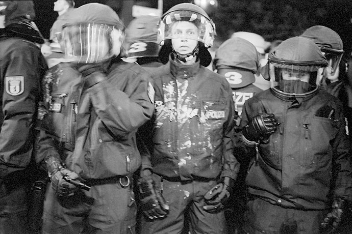 Paint-stained Police officers stand their ground. Image: Michel Meijer