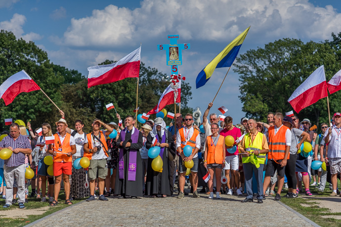 Celebration of Maria ascension in Jasna Góra, Poland 2018. A group of pilgrims stands in front of the Jasna Góra monastery and waves to the priest on the balcony. Image: Michel Meijer