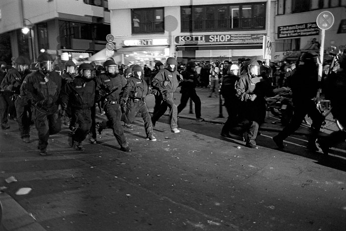 A platoon of police officers make a charge on a group of demonstrators. Image: Michel Meijer