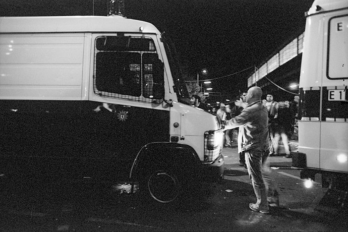 A protester stands in front of a police bus. Image: Michel Meijer