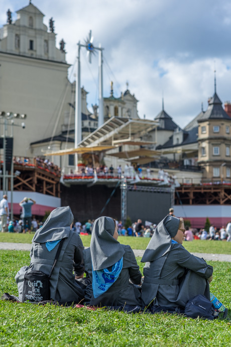 Celebration of Maria ascension in Jasna Góra, Poland 2018. Three nuns are sitting on the meadow in front of the pilgrimage site Jasna Góra. Image: Michel Meijer