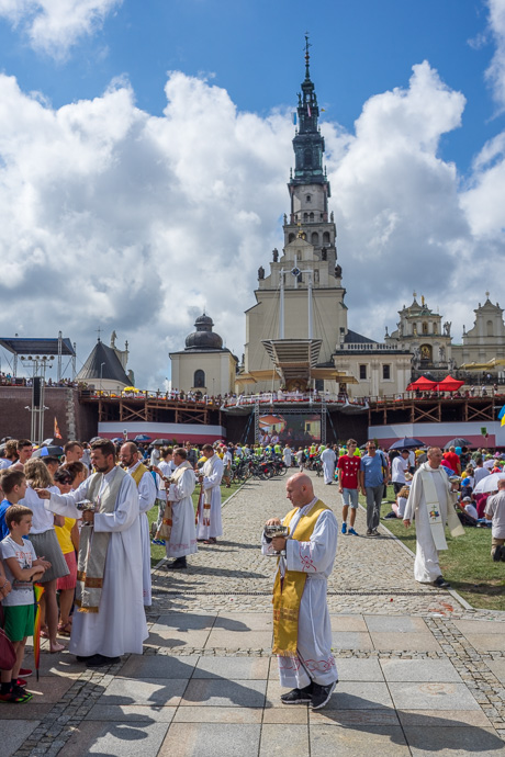 Celebration of Maria ascension in Jasna Góra, Poland 2018. Priests are handing out hosts during a church service on the field in front of the Jasna Góra pilgrimage site. Image: Michel Meijer