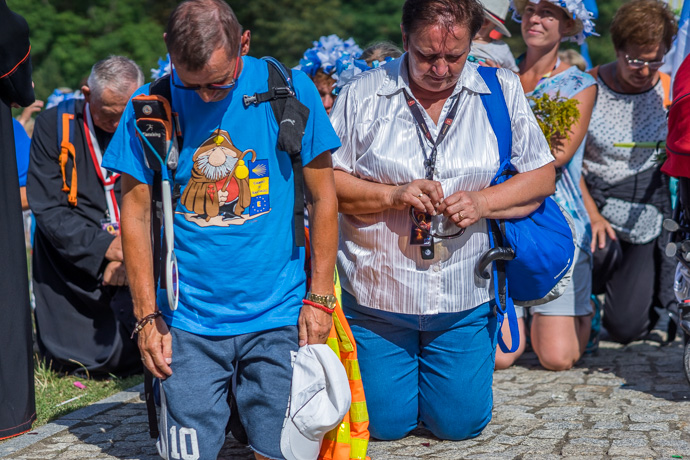 Celebration of Maria ascension in Jasna Góra, Poland 2018. A group of pilgrims kneels and prays in front of the Jasna Góra pilgrimage site.