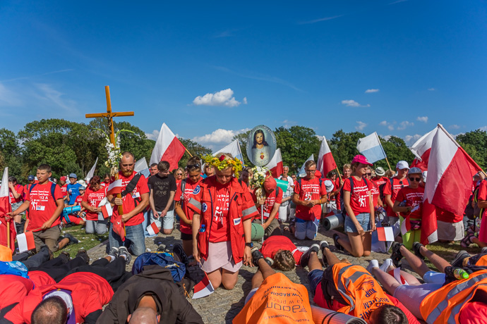 Celebration of Maria ascension in Jasna Góra, Poland 2018. A group of pilgrims kneels and prays in front of the Jasna Góra pilgrimage site. Image: Michel Meijer