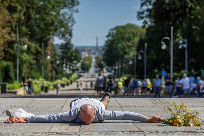 Celebration of Maria ascension in Jasna Góra, Poland 2018. A pilgrim lies on the ground and prays in front of the Jasna Góra pilgrimage site. Image: Michel Meijer
