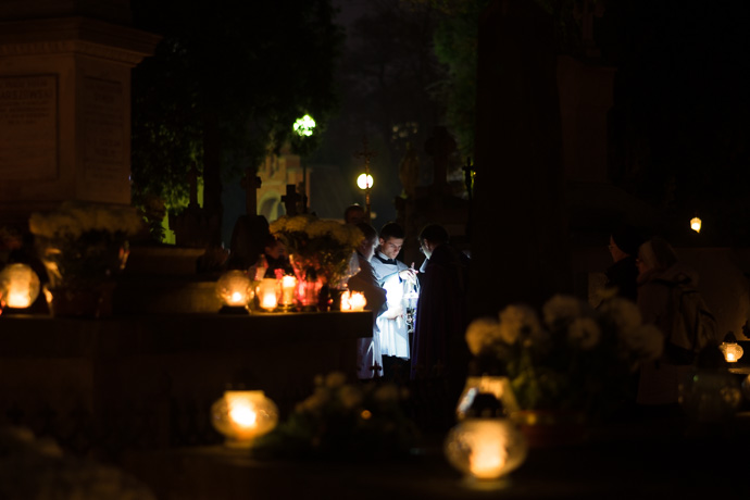 All Saints' Day at Rakowicki Cemetery in Kraków, Poland 2019. A priest gives an evening mass in the cemetery, All Saints' Day in Poland. Image: Michel Meijer