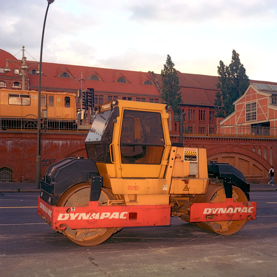 An orange tandem vibratory roller in a street in Berlin. Image: Michel Meijer