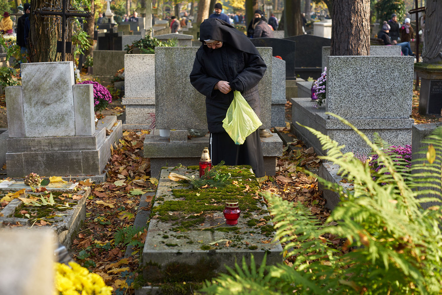 A nun remembers her deceased loved ones at Rakowicki Cemetery in Krakow, Poland 2019 - image: Michel Meijer